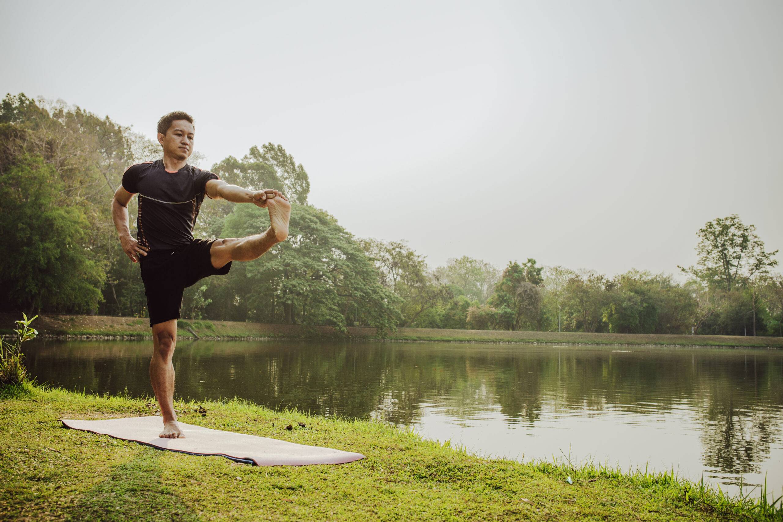 man tretching with yoga nature scaled