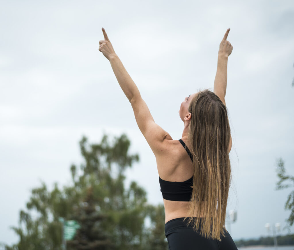 sporty woman raising her hands up